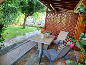 einen Tisch und zwei Stühle auf einer Terrasse in der Unterkunft Skourgias Rooms in Kala Nera