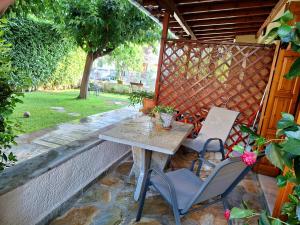 un patio con mesa y 2 sillas en Skourgias Rooms en Kala Nera