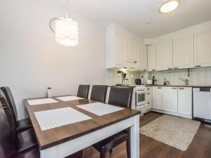 cocina con armarios blancos, mesa y sillas en Holiday Home Lomariekko 6 b 7 by Interhome, en Saariselkä
