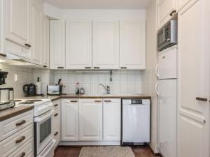 una cocina blanca con electrodomésticos blancos y armarios blancos en Holiday Home Lomariekko 6 b 7 by Interhome, en Saariselkä