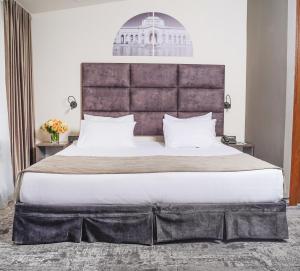 a bedroom with a large bed with a large headboard at Median Hotel, City Center Yerevan in Yerevan +48 photos