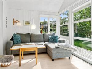 a living room with a couch and a table at Holiday Home Lucie - 50m from the sea in Bornholm by Interhome in Rønne
