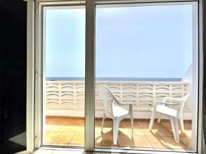 d'un balcon avec deux chaises et une vue sur l'océan. dans l'établissement Apartamento vista mar, a escasos metros de la playa, à Tamaduste