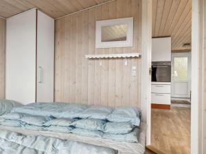 uma cama num quarto com uma parede de madeira em Holiday Home Isabel - 500m from the sea in NW Jutland by Interhome em Torsted