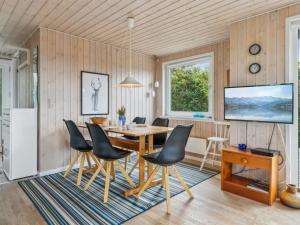 Torsted的住宿－Holiday Home Isabel - 500m from the sea in NW Jutland by Interhome，一间带木桌和椅子的用餐室