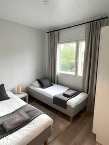 a bedroom with two beds and a window at Moderni paritalo lähellä lentokenttää, free parking, sauna in Vantaa