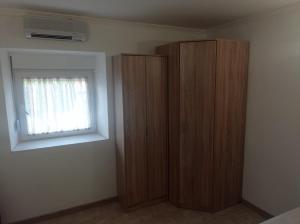 ein Schlafzimmer mit einem Holzschrank und einem Fenster in der Unterkunft Apartman Dardic in Herceg-Novi