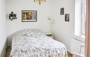 1 dormitorio con 1 cama con colcha de flores en 4 Bedroom Nice Home In Vesls en Arup