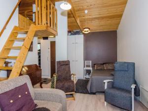 sala de estar con escalera, sofá y sillas en Holiday Home Säästöloma 5 f 22 by Interhome en Nurmes