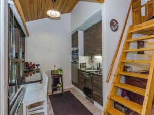 una cocina con armarios de madera y una escalera en una habitación en Holiday Home Säästöloma 5 f 22 by Interhome en Nurmes