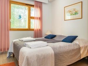 a bedroom with two beds with blue pillows at Holiday Home Lomariekko 6 a 4 pikkuriekko by Interhome in Saariselka