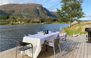 einen Tisch und Stühle auf einer Terrasse neben einem See in der Unterkunft Awesome Home In Straumgjerde With Kitchen 