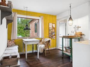 a kitchen with yellow walls and a table and a window at Holiday Home Quiana - 4km from the sea in NW Jutland by Interhome in Torsted