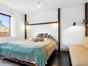 a bedroom with a large bed and a couch at Holiday Home Quiana - 4km from the sea in NW Jutland by Interhome in Torsted