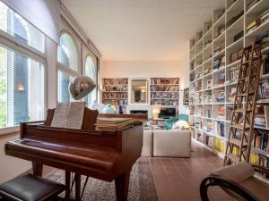 biblioteca con piano en una sala con estanterías en Holiday Home Il Roccolo by Interhome, en Ottiglio