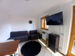 a living room with a couch and a flat screen tv at CASA TATA -Appartamento vista mozzafiato in Lizzola Alta +19 photos