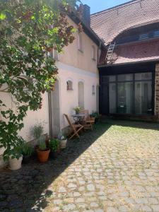 a courtyard of a house with a table and chairs at Studio auf denkmalgeschütztem Dreiseithof in Höfgen bei Grimma in Höfgen