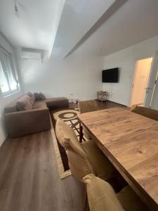 a living room with a wooden table and a couch at Downtown Great Apartment in Strumica