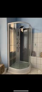 um chuveiro com uma porta de vidro na casa de banho em Chambre privée 2 personnes em Bourganeuf