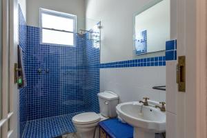 a blue tiled bathroom with a toilet and a sink at Paradise Views Vacation Home in Cape Town +21 photos
