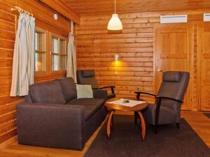 - un salon avec un canapé et deux chaises dans l'établissement Holiday Home Kulta-käkönen 310 by Interhome, à Nurmes