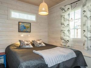 a bedroom with a bed in a room with wooden walls at Holiday Home Kuurankuksa a by Interhome in Sirkka