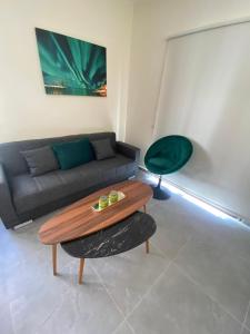 a living room with a couch and a table at Central Two Bedroom Apartment, No 101, by IMH Travel & Tours in Paphos