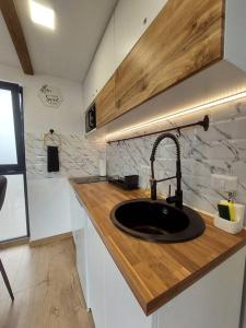 a kitchen with a sink and a wooden counter top at Cozy Cube - tiny house 