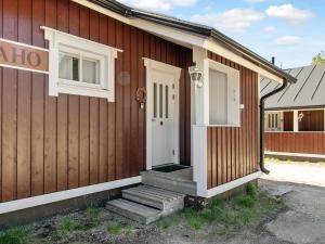 une petite maison avec une porte blanche et des escaliers. dans l'établissement Holiday Home Hirvasaho a4 by Interhome, à Saariselka