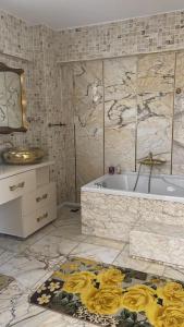 uma casa de banho com uma banheira, um lavatório e um tapete em Gemütliche Villa mit Pool, extravagant, luxuriös em Ula
