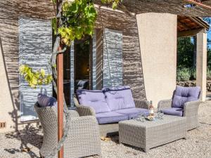 weranda z wiklinowymi krzesłami i stołem z fioletowymi meblami w obiekcie Holiday Home Villa 10 by Interhome w mieście Nans-les-Pins
