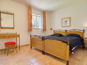 sypialnia z 2 łóżkami, stołem i lustrem w obiekcie Holiday Home Villa 10 by Interhome w mieście Nans-les-Pins