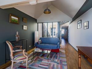 ein Wohnzimmer mit einem blauen Sofa und Stühlen in der Unterkunft Holiday Home by Interhome in Agon Coutainville
