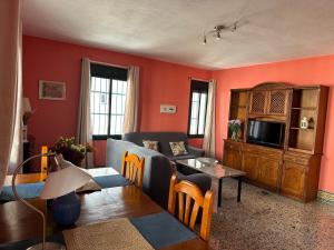 a living room with a couch and a tv at Apartamentos Turísticos Santa Marina in Aracena