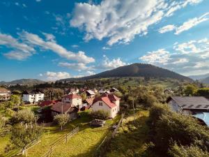 un villaggio sulle colline con una montagna sullo sfondo di STUDIO62 a Câmpulung Moldovenesc