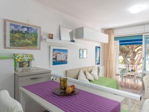 ein Wohnzimmer mit einem Tisch und einem Sofa in der Unterkunft Apartment La Pineta by Interhome in Casa SantʼEugenia