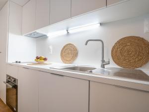 een keuken met witte kasten en een spoelbak bij Holiday Home Arbenn 2 by Interhome in Tréguier