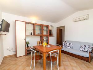 uma sala de estar com uma mesa e cadeiras e um sofá em Apartment Fertas by Interhome em La Caletta