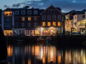 a city with buildings and a river at night at Apartment Lighthouse View by Interhome in Mevagissey
