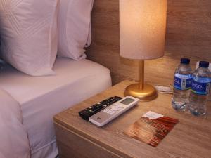 uma mesa com controlo remoto e garrafas de água numa cama em Hotel Casa Agustina em Cartagena das Índias