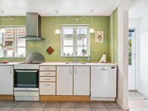 uma cozinha com electrodomésticos brancos e paredes verdes em Apartment Annaline - all inclusive - 1-2km to the inlet by Interhome em Nykobing Sjaelland