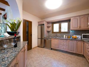 eine große Küche mit Holzschränken und Granitarbeitsflächen in der Unterkunft Villa El Salvador by Interhome in Benissa