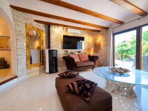 ein Wohnzimmer mit einem Tisch und einer Ziegelwand in der Unterkunft Villa El Salvador by Interhome in Benissa