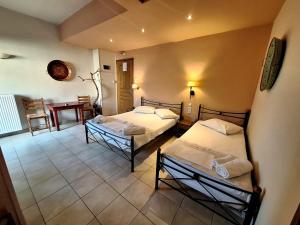 um quarto com duas camas e uma mesa em Skourgias Rooms em Kala Nera