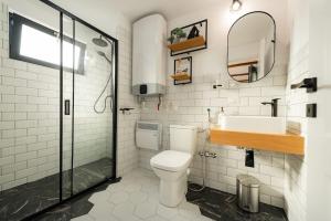 a bathroom with a toilet and a sink and a mirror at Cozy Cube - tiny house 