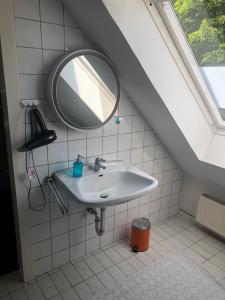 a bathroom with a sink and a mirror at Stilvolles Apartment im grünen Münsterland 