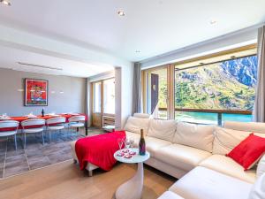 a living room with a white couch and a table at Apartment Le Shamrock - Le Lac-6 by Interhome in Tignes