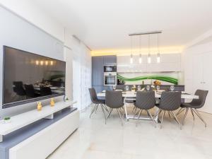 a kitchen and dining room with a large television and a dining table at Holiday Home Nika by Interhome in Malinska +39 photos