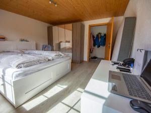 a bedroom with a bed and a laptop on a desk at Apartment Uf dr Fuhre by Interhome in Adelboden