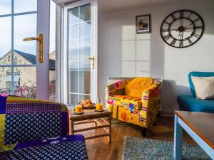 a living room with a couch and a clock on the wall at Apartment Helland by Interhome in Pentewan